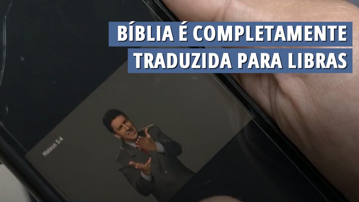Bíblia aberta ao lado de mãos sinalizando em Libras